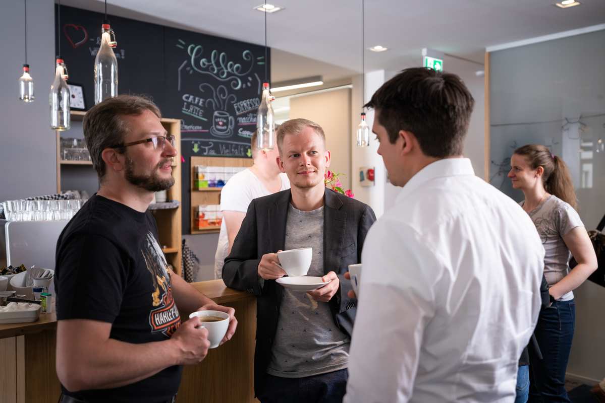 3 people talking at a coffee counter